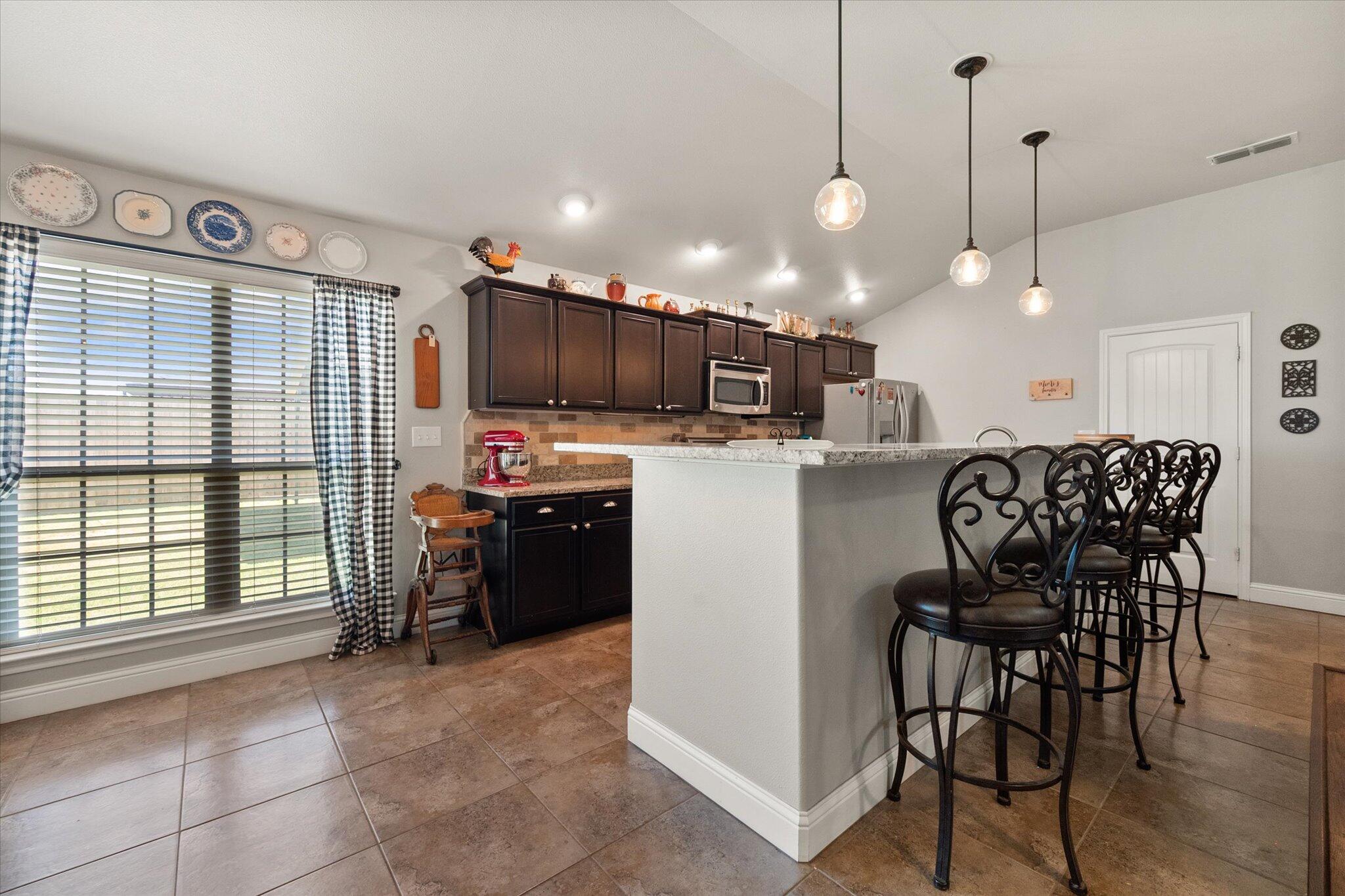 3106 128th Street Lubbock, TX 79423 - Photo 14 of 44 a kitchen with a dining table chairs and white cabinets