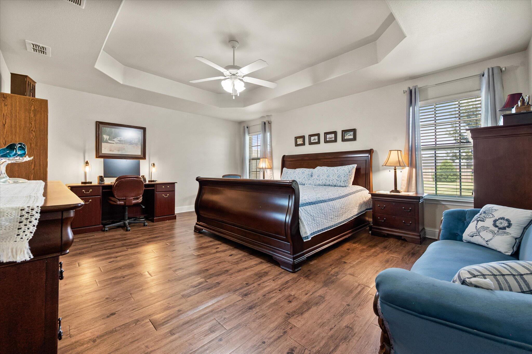 3106 128th Street Lubbock, TX 79423 - Photo 21 of 44 a spacious bedroom with a bed and wooden floor
