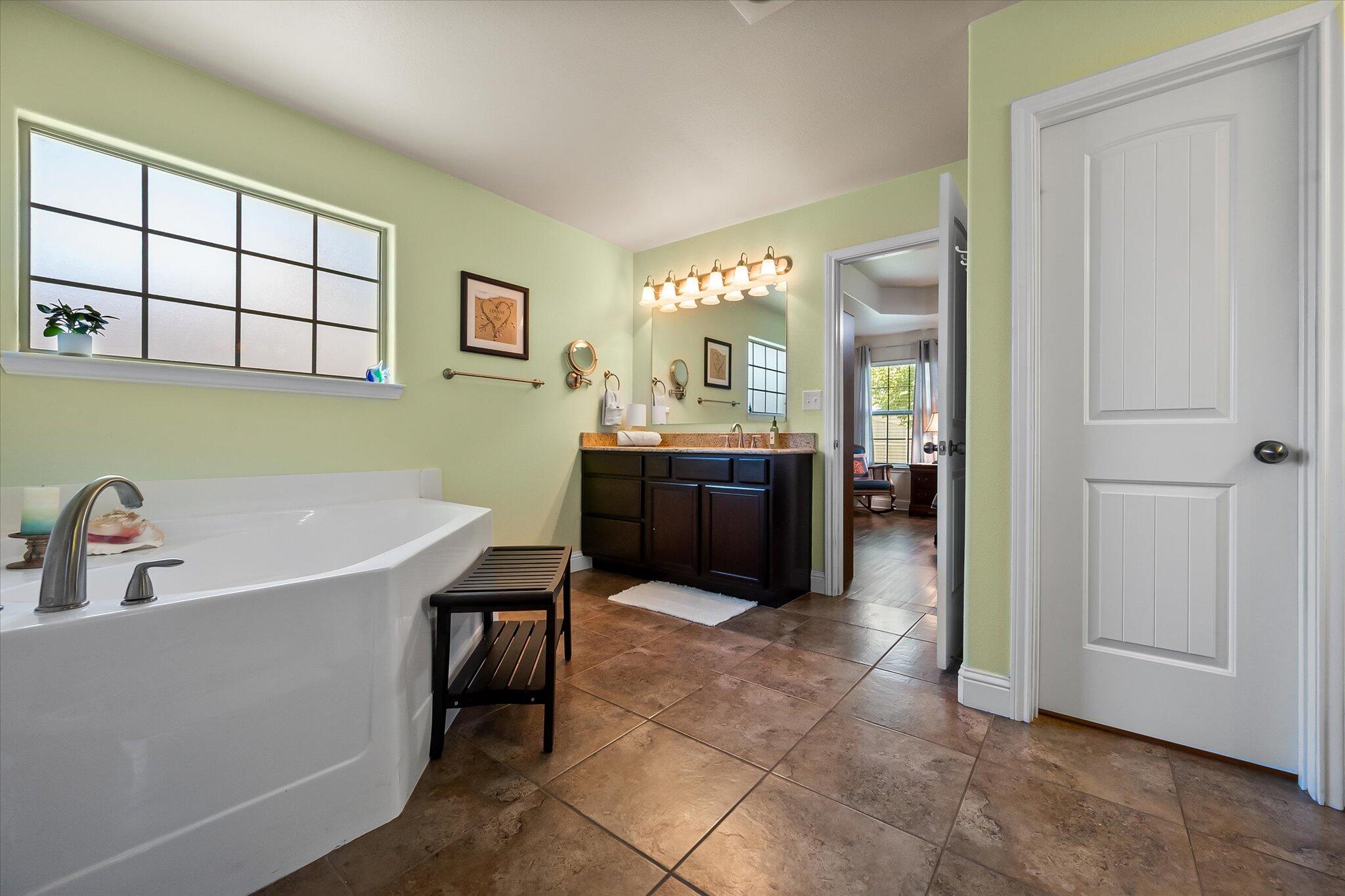 3106 128th Street Lubbock, TX 79423 - Photo 24 of 44 a spacious bathroom with a tub sink and mirror