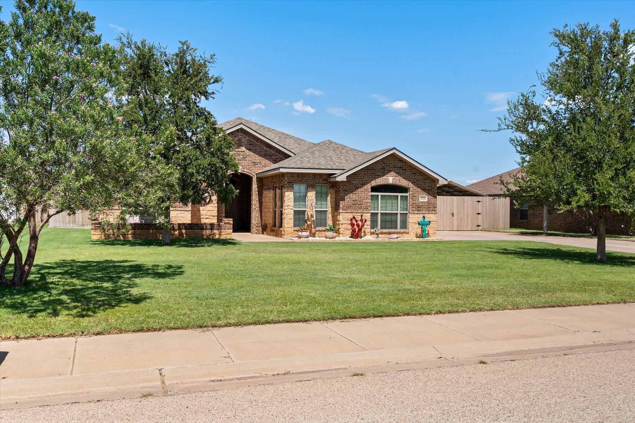 3106 128th Street Lubbock, TX 79423 - Photo 3 of 44 a view of a house next to a yard with big trees