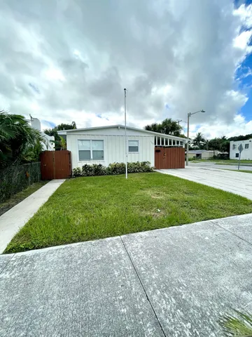 a view of a house with a yard and sitting area