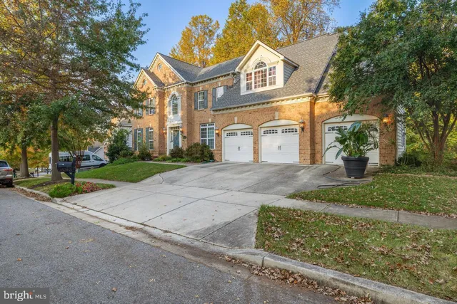a view of a white house with a yard and large tree