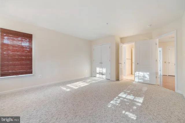 an empty room with wooden floor and entryway