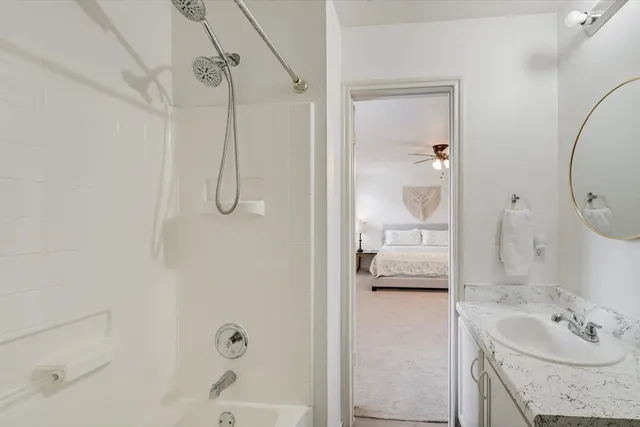 a bathroom with a granite countertop bathtub shower sink and vanity