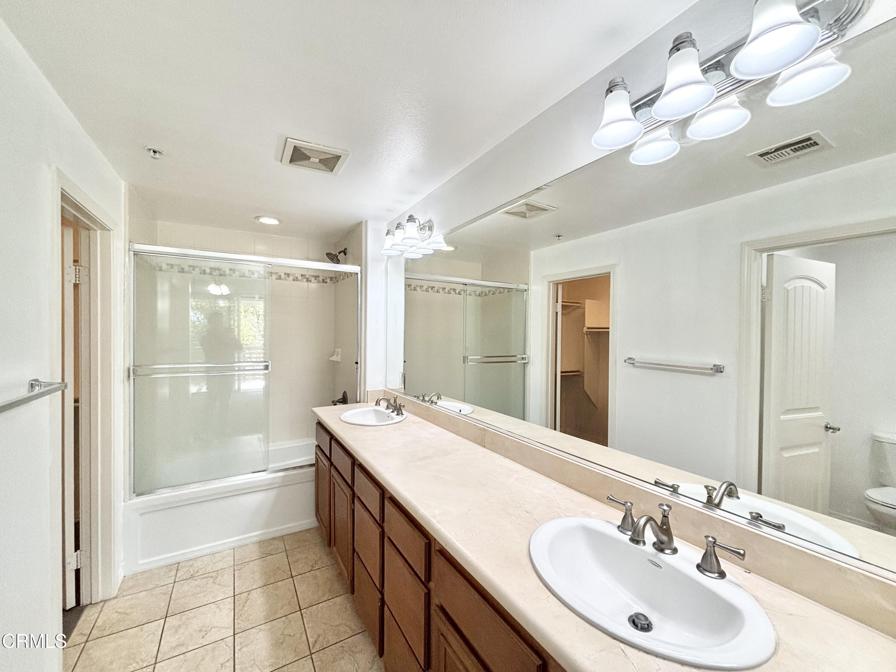 1544 Windshore Way Oxnard, CA 93035 - Photo 14 of 27 a bathroom with a double vanity sink mirror and shower