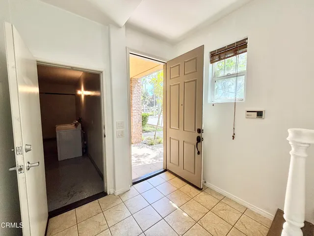 a view of a hallway with wooden floor and a room