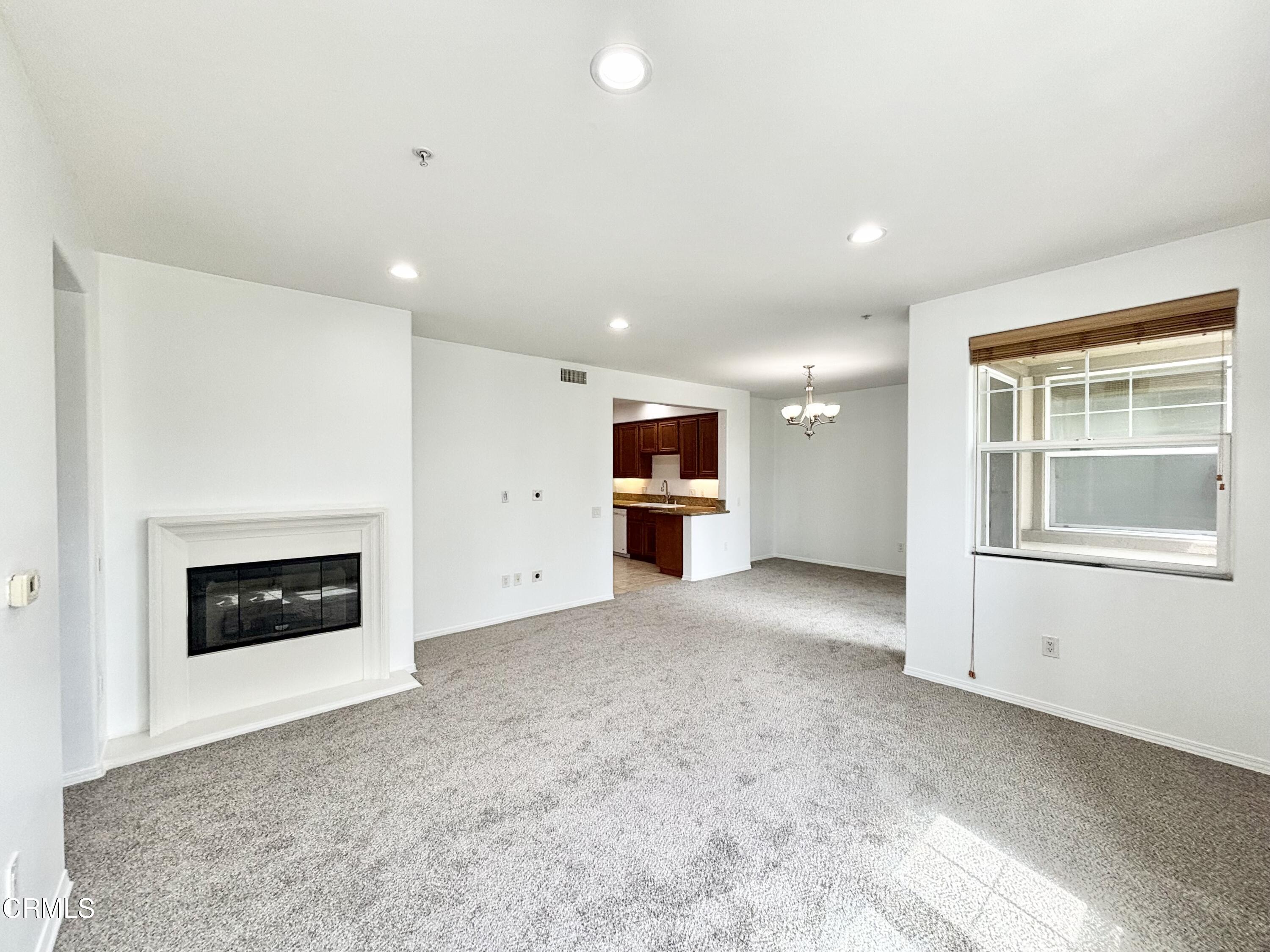 1544 Windshore Way Oxnard, CA 93035 - Photo 2 of 27 an empty room with a fireplace and window