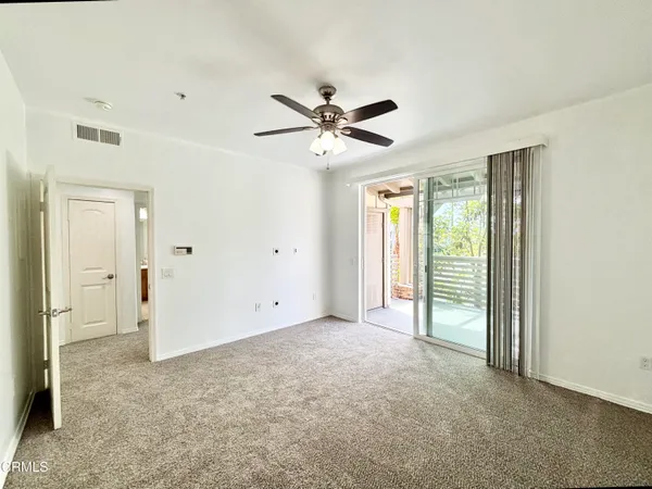 a view of a livingroom with a ceiling fan and window