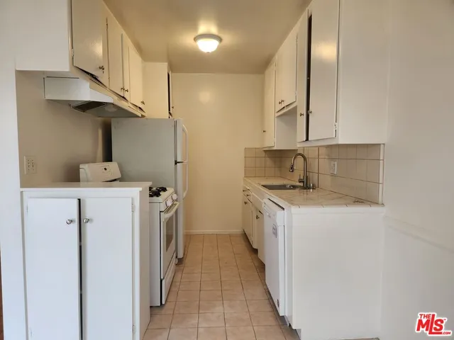 a kitchen with a sink a stove and a refrigerator