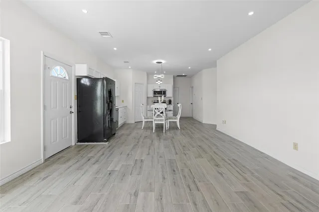 a view of a kitchen with refrigerator and wooden floor