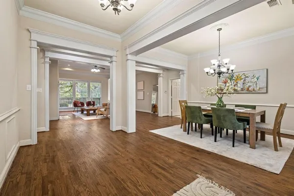a dining room with wooden floor and a chandelier
