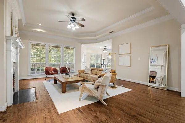 an empty room with wooden floor fireplace and windows