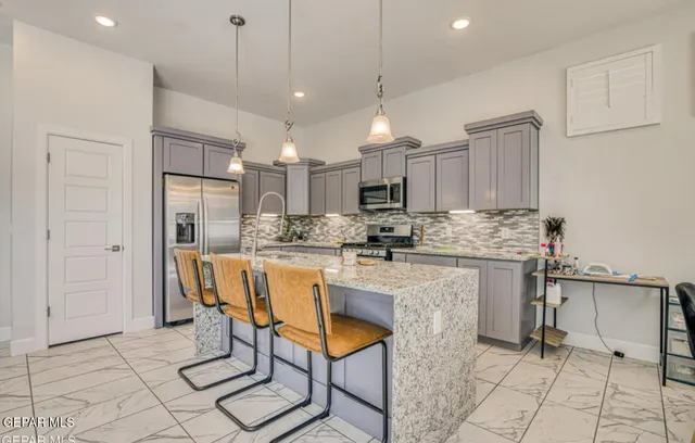 a kitchen with stainless steel appliances kitchen island granite countertop a sink and cabinets