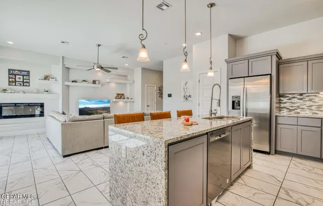 a kitchen with stainless steel appliances granite countertop a sink stove and refrigerator