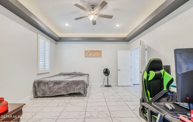 a spacious bedroom with a bed and a flat screen tv