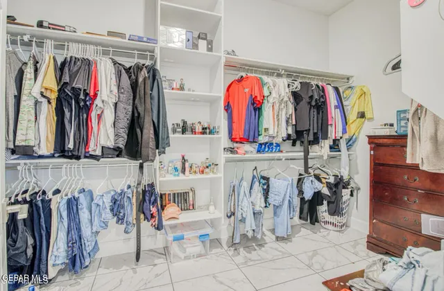 a view of walk in closet with clothes