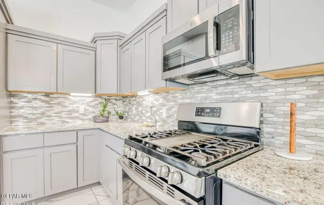 a stove top oven sitting inside of a kitchen
