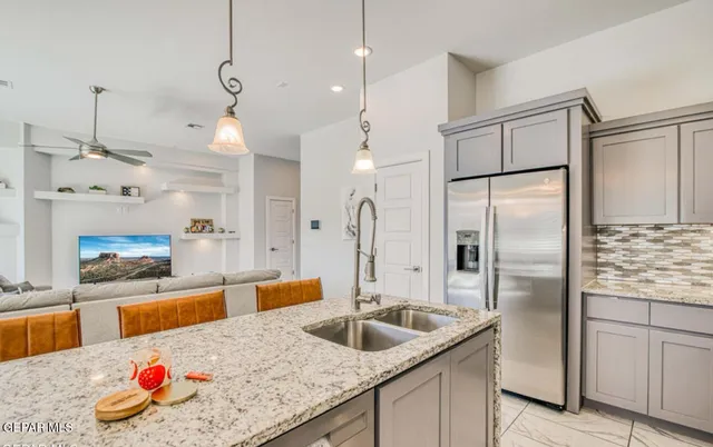 a kitchen with stainless steel appliances granite countertop a refrigerator a sink and a stove