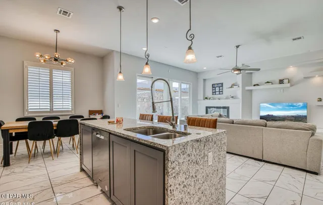 a kitchen with granite countertop a sink a counter top space appliances and cabinets
