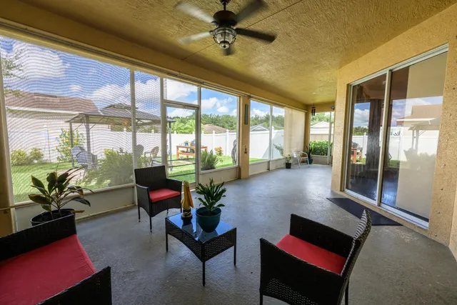 a living room with furniture and floor to ceiling windows