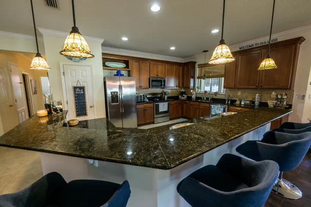 a kitchen with stainless steel appliances granite countertop a sink a stove and a refrigerator