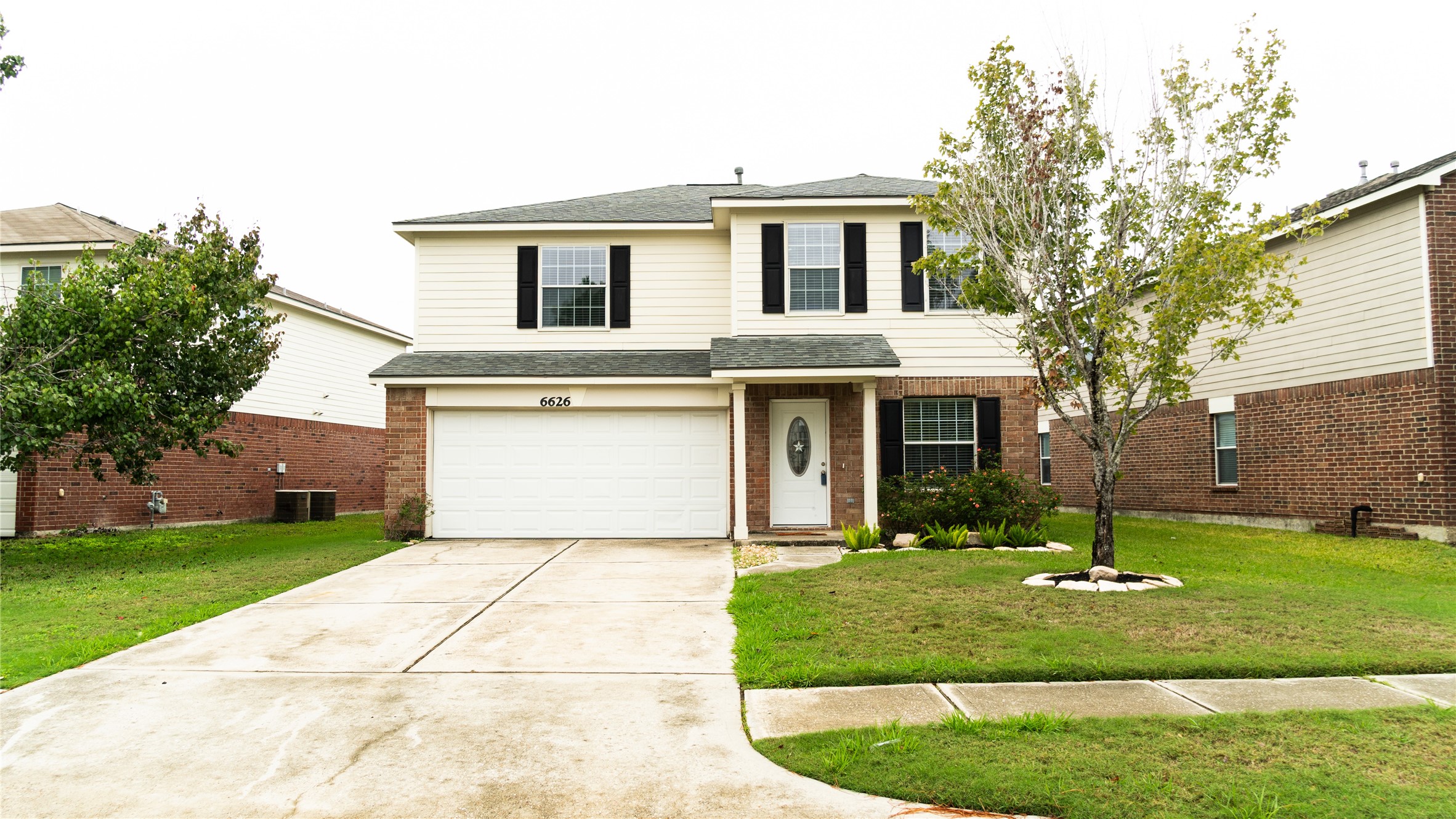 a front view of a house with a yard and trees