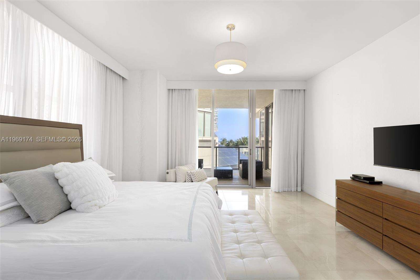 9701 Collins Avenue, Unit 404S Bal Harbour, FL 33154 - Photo 11 of 40 a bedroom with a bed and a flat screen tv