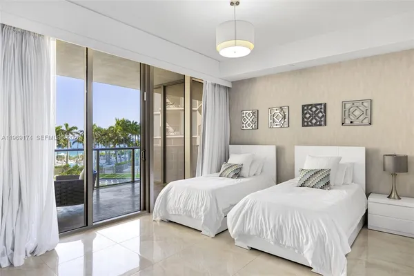 a bedroom with two large bed and a large window