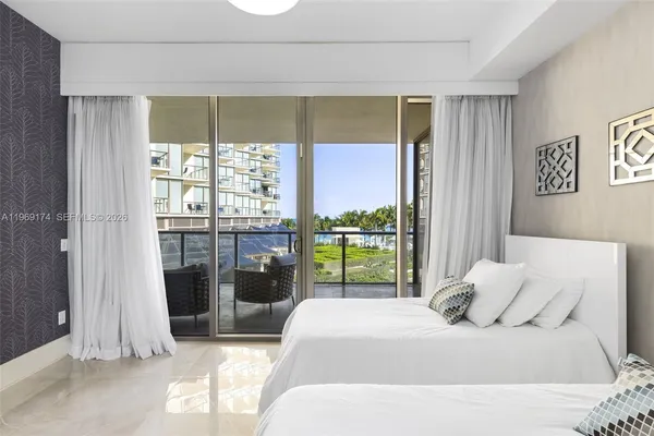 a bedroom with a balcony a large bed and a window