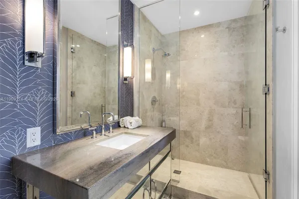 a bathroom with a granite countertop sink a mirror and a bathtub