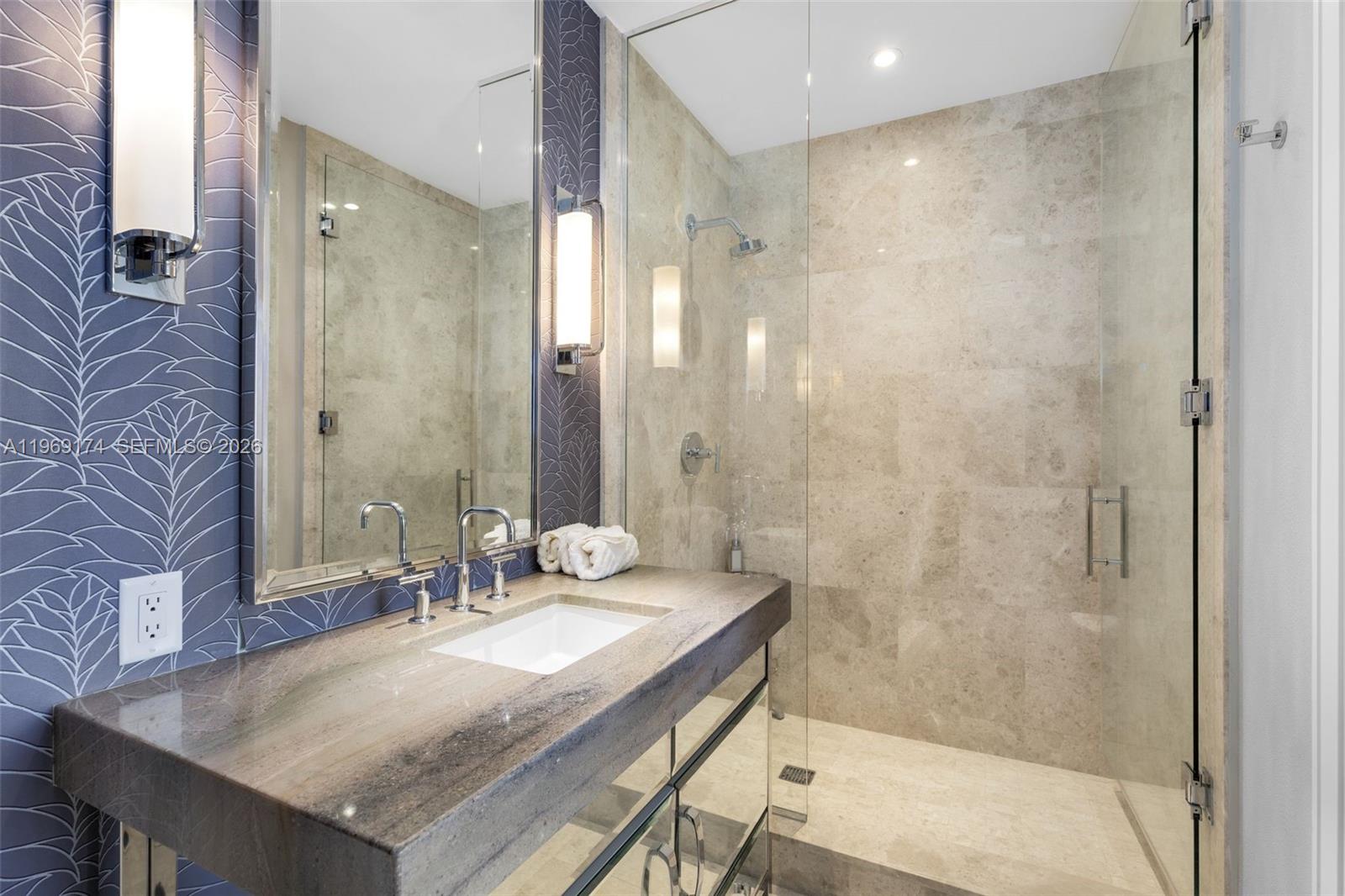 9701 Collins Avenue, Unit 404S Bal Harbour, FL 33154 - Photo 18 of 40 a bathroom with a granite countertop sink a mirror and a bathtub