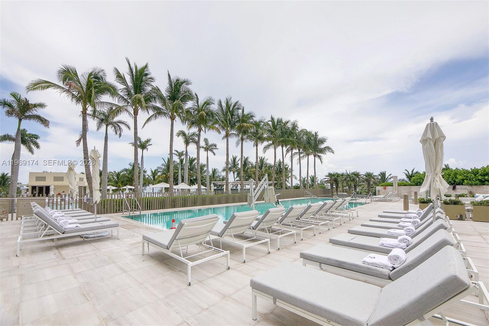 9701 Collins Avenue, Unit 404S Bal Harbour, FL 33154 - Photo 33 of 40 a view of a patio with a dining table and chairs with swimming pool
