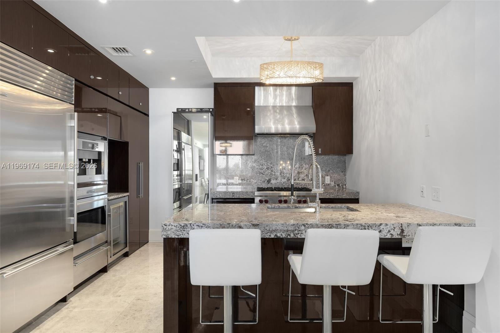 9701 Collins Avenue, Unit 404S Bal Harbour, FL 33154 - Photo 8 of 40 a kitchen with kitchen island granite countertop a sink and refrigerator