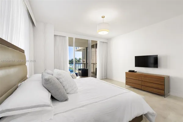 a bedroom with bed and flat screen tv