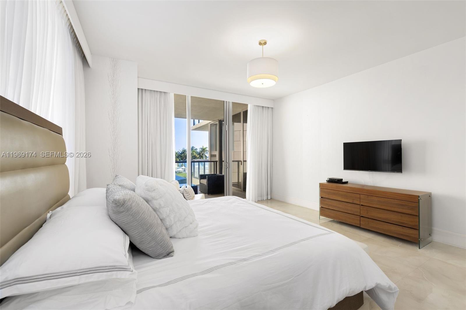 9701 Collins Avenue, Unit 404S Bal Harbour, FL 33154 - Photo 10 of 40 a bedroom with bed and flat screen tv