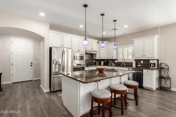 a kitchen with a refrigerator a sink and chairs