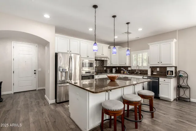 a kitchen with a refrigerator a sink and chairs