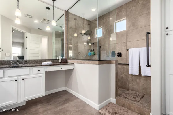 a bathroom with a sink a large mirror and a shower