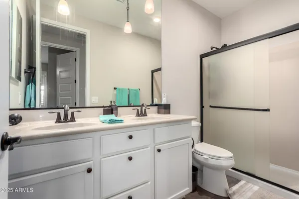 a bathroom with a toilet sink double vanity and mirror