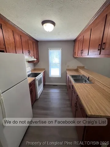 a kitchen with a stove a refrigerator and a sink