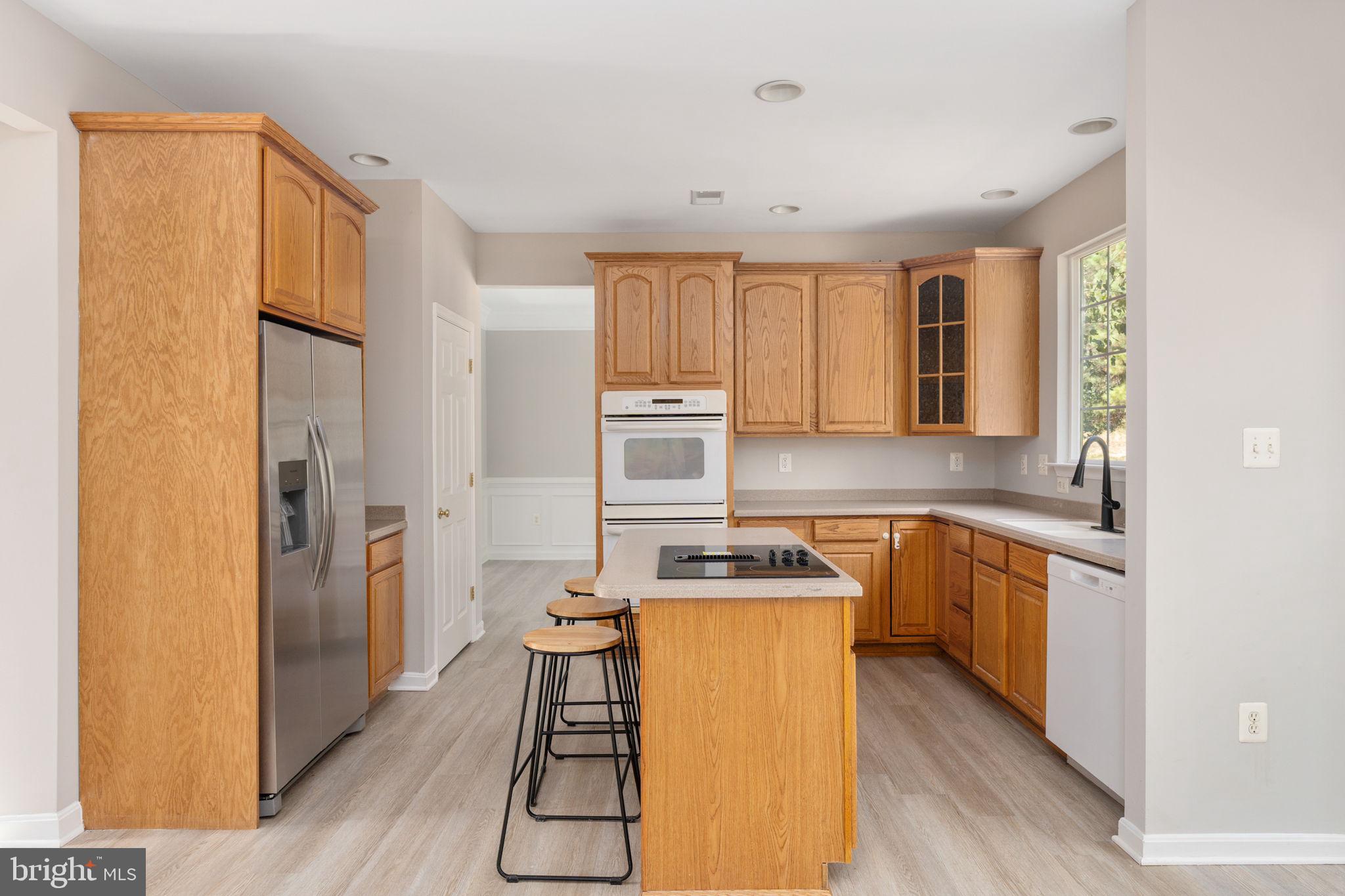 55 Hamstead Road Fredericksburg, VA 22405 - Photo 19 of 58 a kitchen with a refrigerator a stove top oven and wooden floors