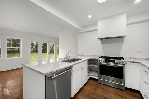 a kitchen with a sink a refrigerator and a stove top oven