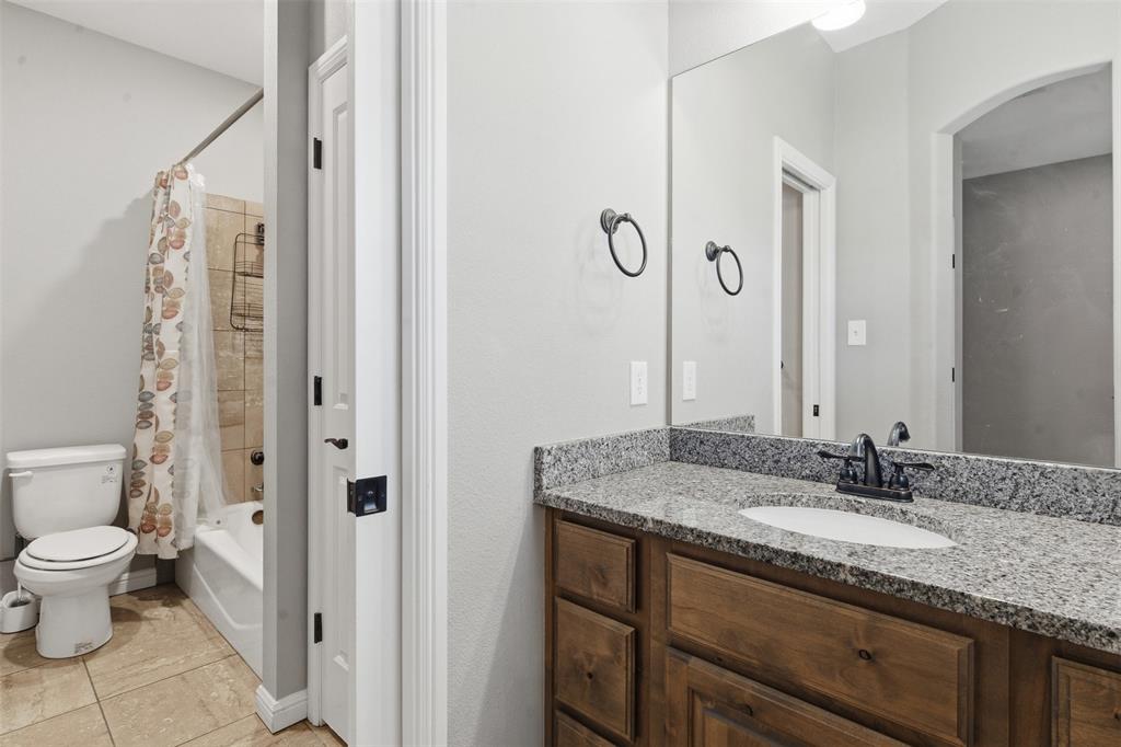 1617 Hawthorne Street Cleburne, TX 76033 - Photo 11 of 40 a bathroom with a granite countertop sink and a mirror