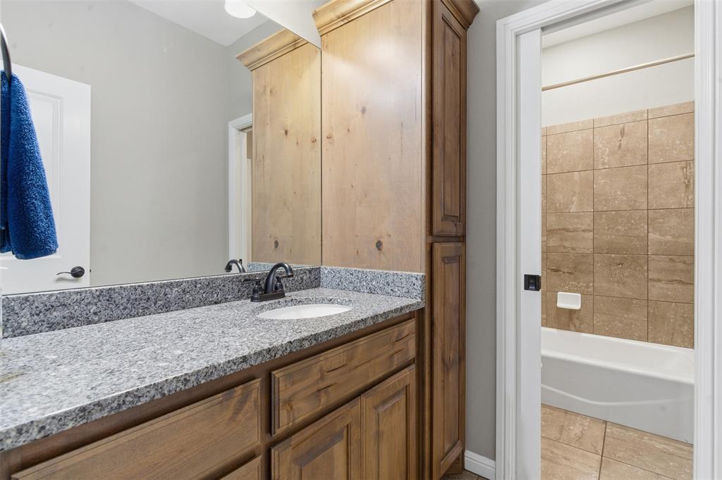 1617 Hawthorne Street Cleburne, TX 76033 - Photo 12 of 40 a bathroom with a granite countertop sink and a mirror