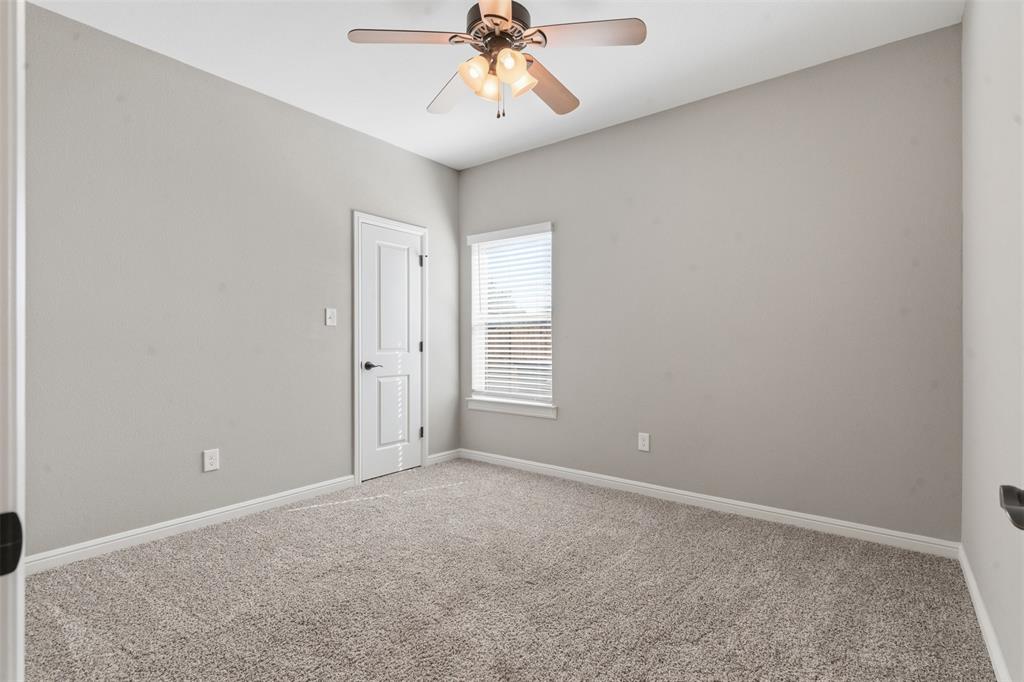 1617 Hawthorne Street Cleburne, TX 76033 - Photo 13 of 40 an empty room with a chandelier fan and windows