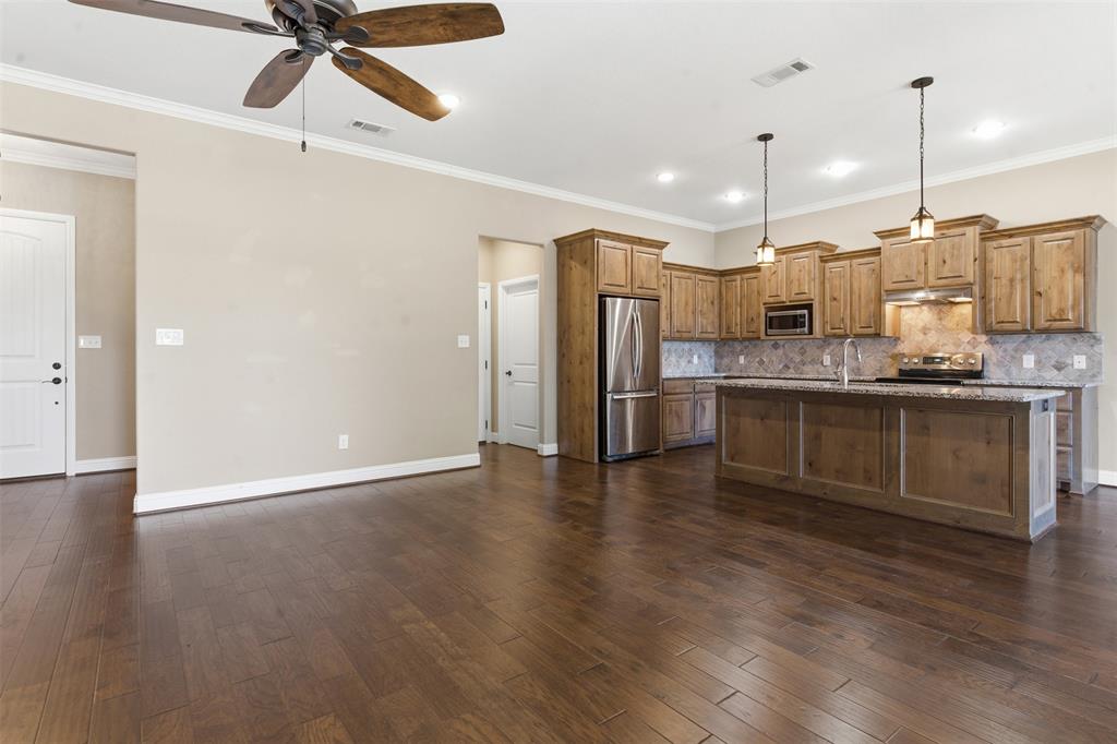 1617 Hawthorne Street Cleburne, TX 76033 - Photo 16 of 40 a kitchen with stainless steel appliances granite countertop a refrigerator a sink and wooden floors