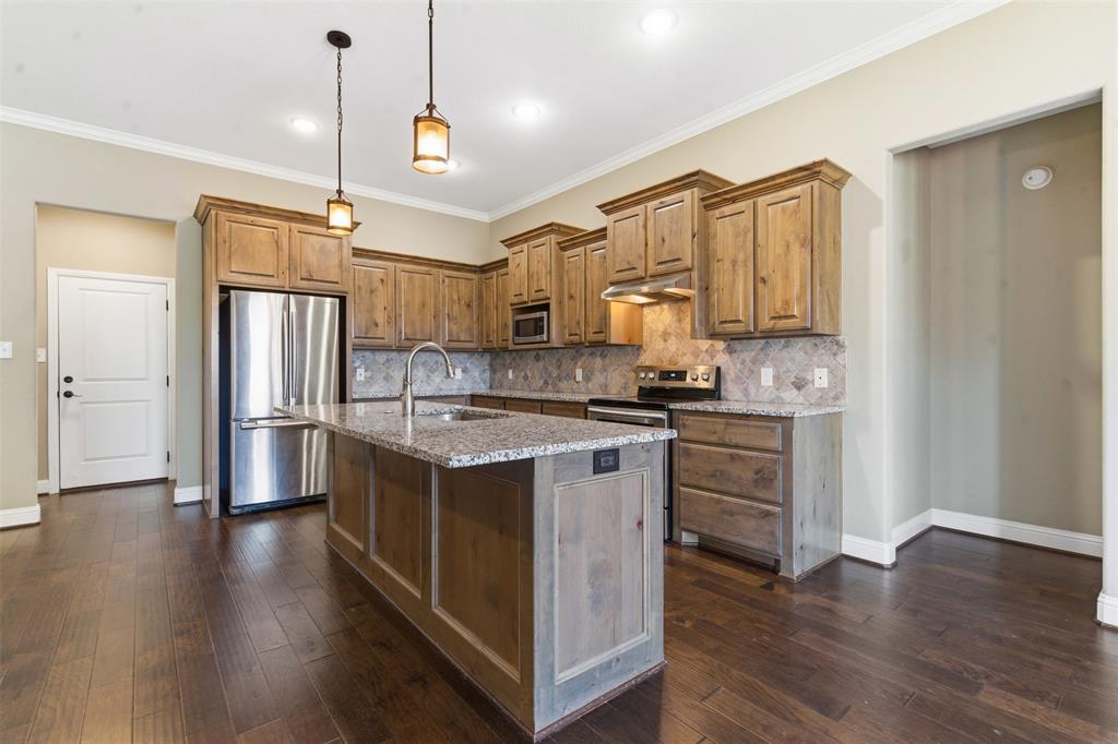 1617 Hawthorne Street Cleburne, TX 76033 - Photo 21 of 40 a kitchen with stainless steel appliances granite countertop a refrigerator a stove and a wooden floors