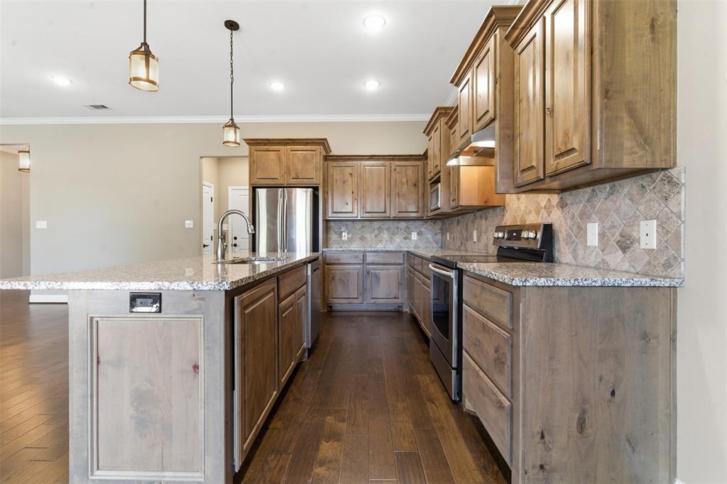 1617 Hawthorne Street Cleburne, TX 76033 - Photo 24 of 40 a kitchen with stainless steel appliances granite countertop a sink a stove and a refrigerator