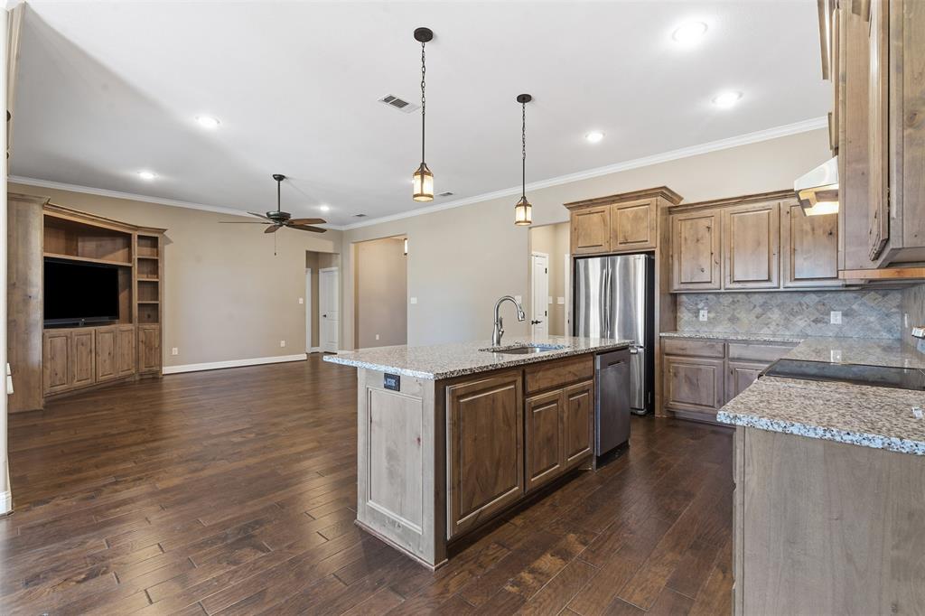 1617 Hawthorne Street Cleburne, TX 76033 - Photo 25 of 40 a kitchen with stainless steel appliances granite countertop a sink a stove and a wooden floors