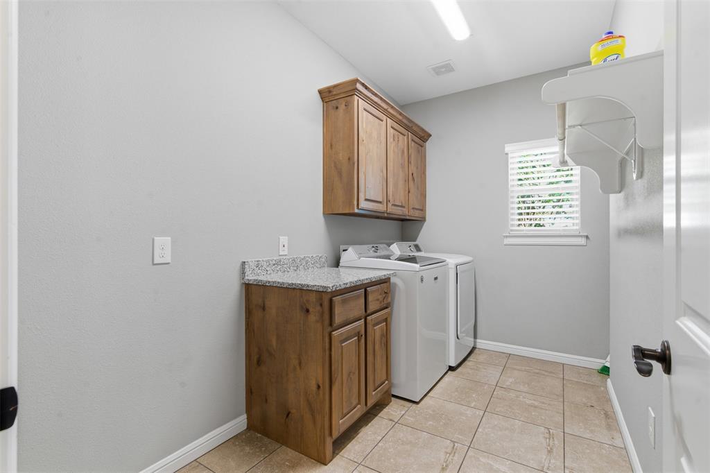 1617 Hawthorne Street Cleburne, TX 76033 - Photo 26 of 40 a utility room with cabinets washer and dryer